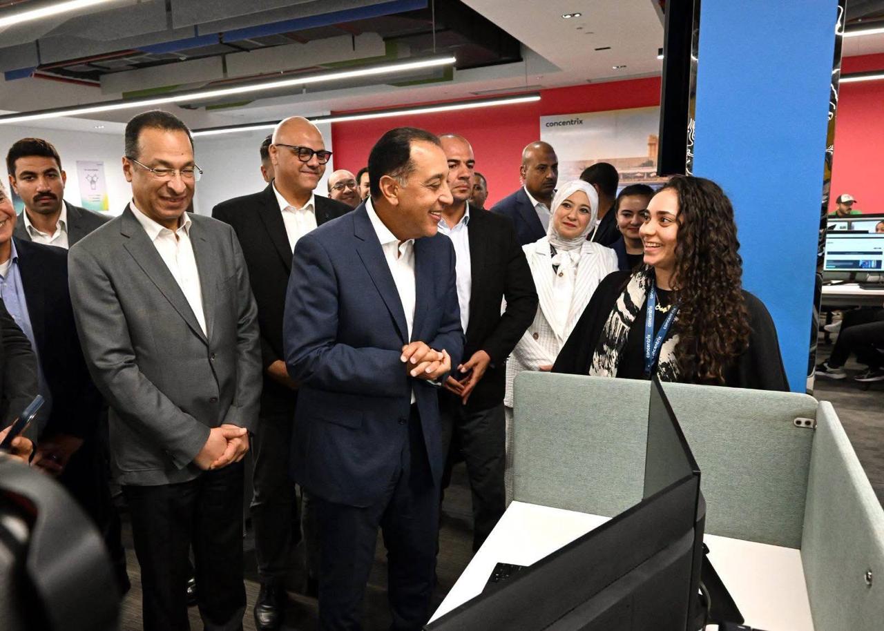 رئيس الوزراء الدكتور مصطفى مدبولي والوزير رأفت هندي يتحدثان مع إحدى الشابات العاملات بشركة كونسنتركس Concentrix  بالإسكندرية
